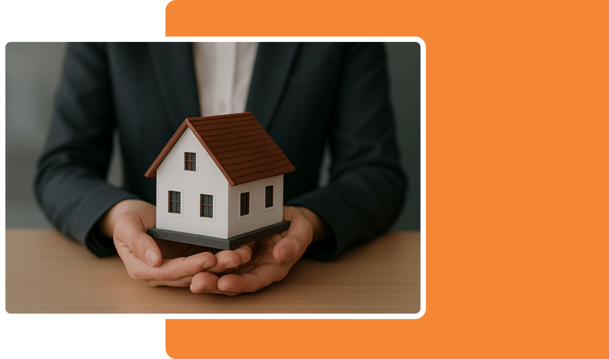 Person in a suit holding a model of a house
